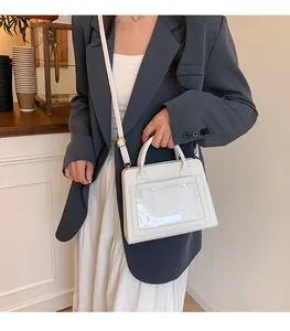 Dettaglio della borsa bianca con finestra in PVC trasparente e finiture in metallo oro