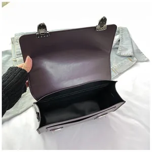 Detail view of the dark purple JK style bag's interior compartment and metal buckles