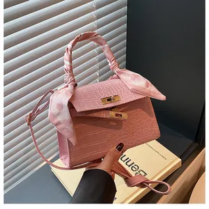 Detailed macro view of pink crocodile pattern texture and gold clasp on the bag