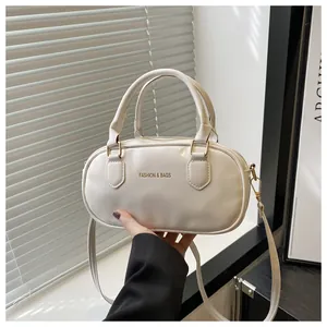 Detail of white leather mini Boston bag with gold FASHION & BAGS logo and dual handles