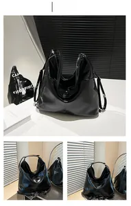 Detail shot of black patent leather tote bag showing shiny mirror finish and hobo style