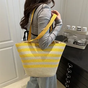 Chic yellow and white striped straw tote bag with bamboo handles for summer beach trips