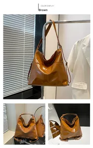 Detail of glossy brown faux leather tote bag showing smooth texture and adjustable strap