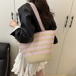 Handmade woven tote bag with pink and gold stripes, bamboo handle, and canvas shoulder strap
