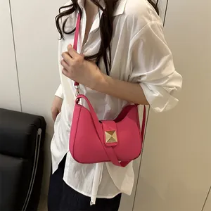 Rose red shoulder bag with gold metal buckle and adjustable strap on a female model