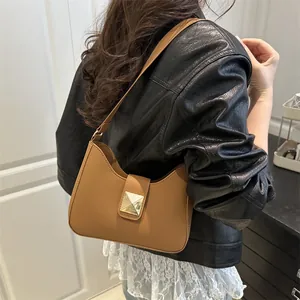 Brown half-moon crossbody bag with gold square buckle shown on model in modern interior