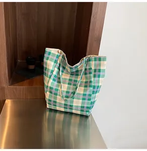 Detail of green and white plaid tote bag showing large capacity and checkered fabric texture