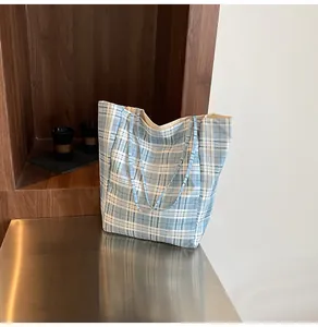 Detail of blue and white checkered canvas tote bag with spacious open-top design