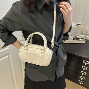Retro cream white Boston bag with handles and adjustable strap for women in a lifestyle setting