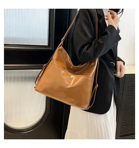 Caramel glossy leather tote bag showing side shoulder strap details and large capacity