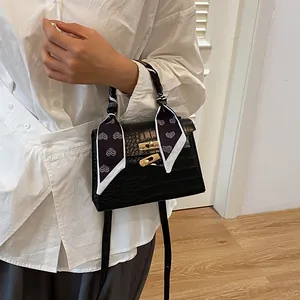 Classic black crocodile pattern handbag with gold clasp and silk scarf handle