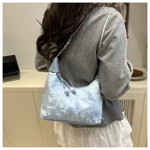 Detailed embroidery of flowers and butterflies on a light blue lace hobo bag for women