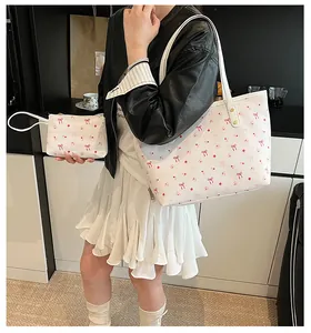 Détails du sac blanc au motif de cerises avec petits nœuds et rivets dorés fins