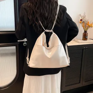 Minimalist white glossy tote bag with soft pleated texture worn by model in elegant setting