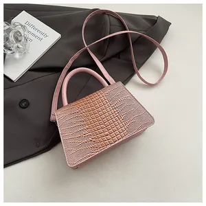Close-up of pink faux crocodile texture leather handbag on grey suit background