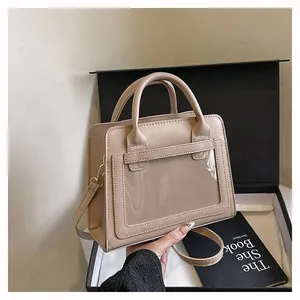 Dettaglio della borsa beige in pelle con finestra in PVC trasparente e tracolla regolabile