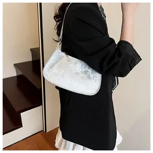 Modèle portant un sac à bandoulière blanc brodé avec relief élégant de papillon