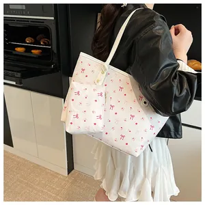 Détail du grand sac cabas blanc à imprimé cerise avec sa petite pochette assortie