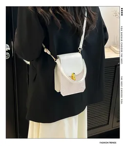 White faux leather mini bag with animal texture detail and gold twist lock closure