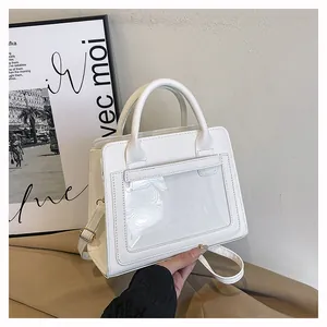 Dettaglio della borsa a tracolla bianca con tasca in PVC trasparente e fibbie d'oro