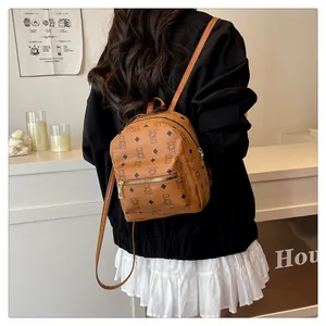 Detailed back view of a brown backpack featuring cartoon bear prints and golden zippers