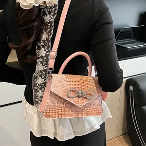 Pink faux crocodile leather handbag with rhinestone bow buckle and adjustable strap
