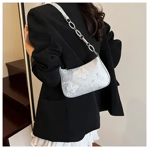 Detail of silver crossbody bag with 3D butterfly embroidery and chain strap