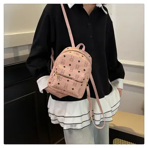 Close-up of pink mini backpack with cute black bear prints and golden metal hardware
