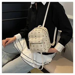 Detail of cute bear pattern on cream PU leather backpack with gold metal hardware