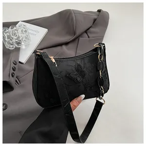 Detail of black jacquard fabric bag with 3D butterfly applique and gold chain