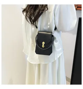 Close-up of black crossbody phone bag with woven texture and gold oval metal clasp