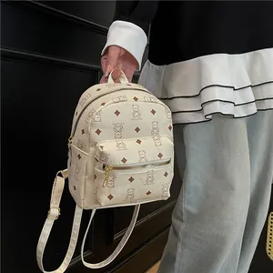 Chic beige mini backpack with bear pattern, featuring litchi grain leather and gold zippers
