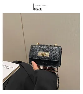 Close-up of black textured mini crossbody bag with gold rotating lock and chain strap