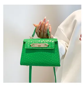 Vue détaillée d'un mini sac à main vert à texture crocodile avec fermoir rotatif doré