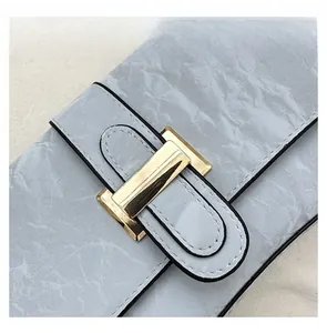 Gros plan du fermoir doré et de la texture en cuir plissé du sac baguette chic