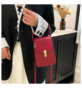 Detail of red mini handbag with woven texture, metal lock, and elegant shoulder strap