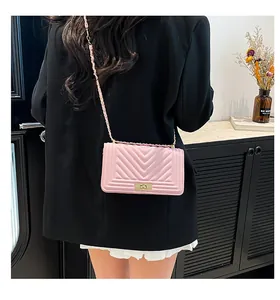 Détail d'un sac à bandoulière en cuir matelassé rose avec chaîne et fermoir en métal