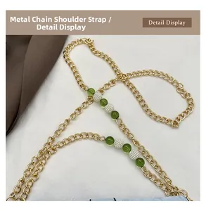 Détail de la bandoulière en chaîne dorée avec perles vertes et blanches pour sac à main