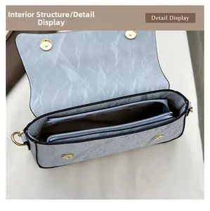 Détail de l'intérieur du sac à main bleu clair avec boucles magnétiques et compartiment