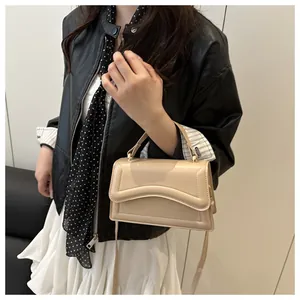 Détail d'un sac à main beige minimaliste avec rabat superposé et bandoulière réglable