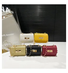 Close-up of mini woven crossbody bags with chain straps and metal locks in five colors