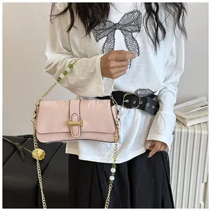 Détail du sac bandoulière rose clair avec boucle H dorée et chaîne perlée