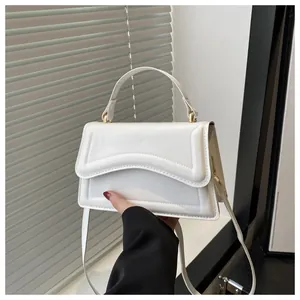 Gros plan d'un sac blanc à motif de vagues avec des anneaux en métal doré sur la poignée