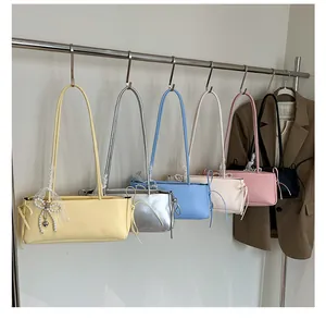 Bunte rechteckige Schultertaschen mit Perlenbogen und Spitzenanhängern an Haken