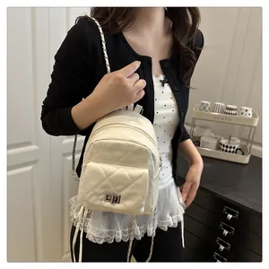 Detail of cream mini quilted backpack with chain straps and metal twist lock on pocket