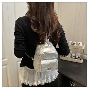 Close-up of silver metallic quilted mini backpack with chain strap and twist-lock pocket