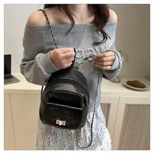 Close-up of elegant quilted texture and metallic chain strap on a black mini backpack
