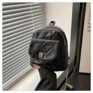 Detail of black quilted chain backpack featuring classic diamond stitching and metal lock