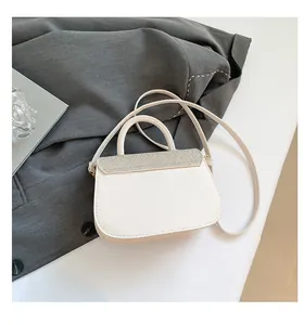 Detail van de witte leren crossbody tas met fonkelende zilveren lovertjes en handvat