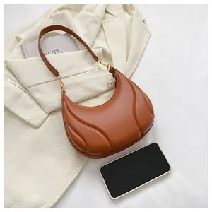 Détail du sac hobo marron avec texture gaufrée et comparaison de taille avec un smartphone